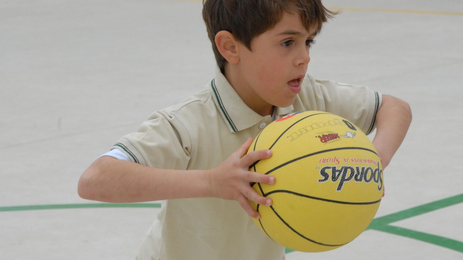 Bild zeigt einen Jungen, der einen Basketball werfen möchte.