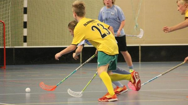 Bild zeigt Kinder beim Floorball spielen.