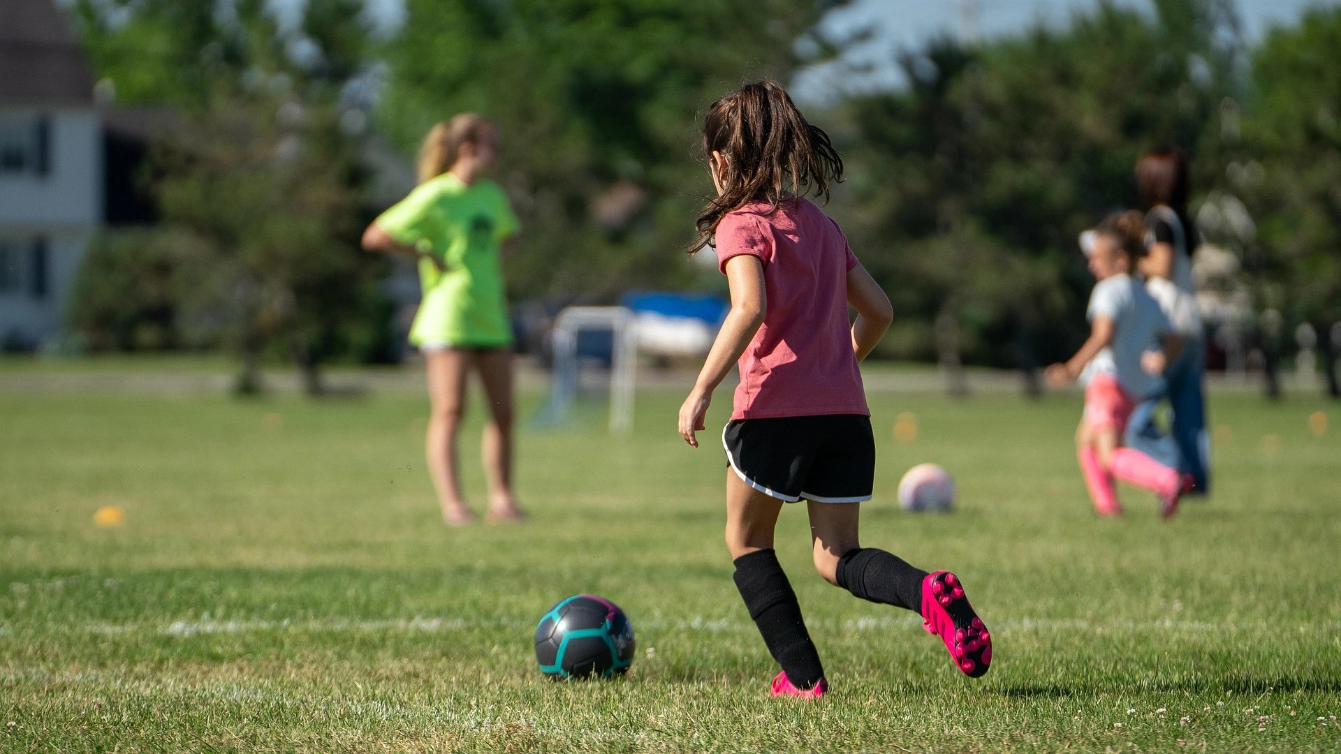 Bild zeigt Kinder beim Fußballspielen auf dem Platz.