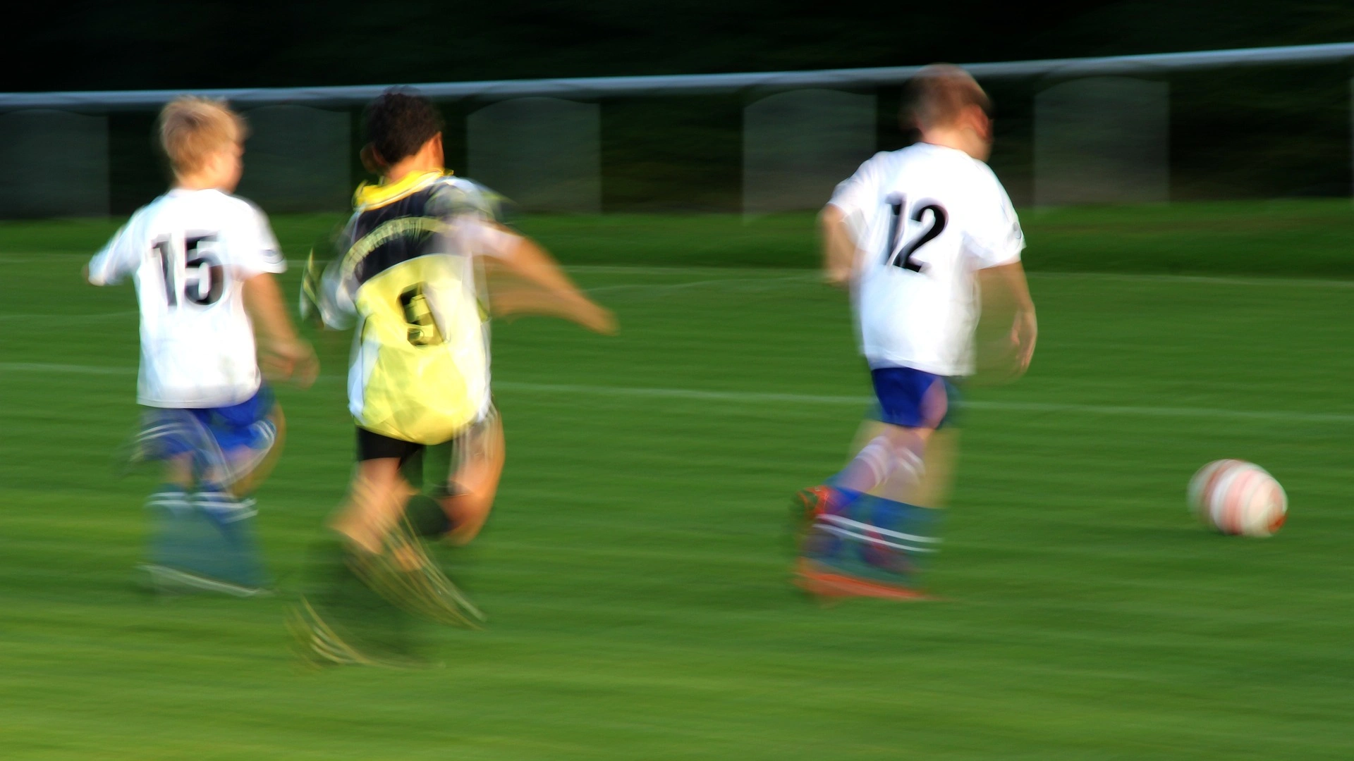Bild zeigt Kinder beim Fußballspielen auf dem Platz.