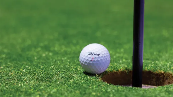 Bild zeigt einen Golfball kurz vor dem Loch.