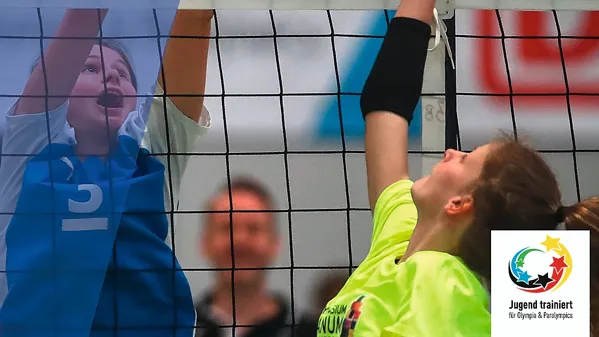 Bild zeigt zwei Volleyballspielerinnen am Netz in einer Nahaufnahme.