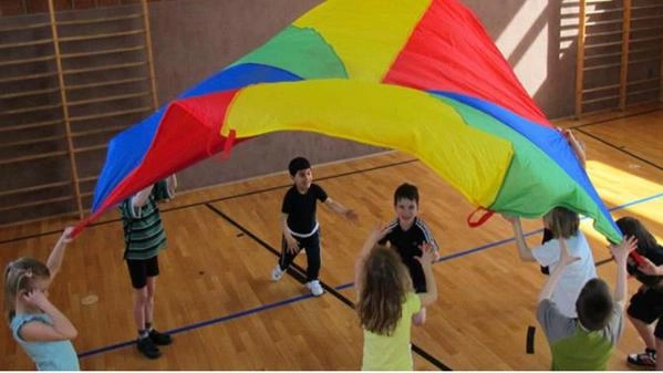 Kinder spielen mit einem Schwungtuch in der Halle