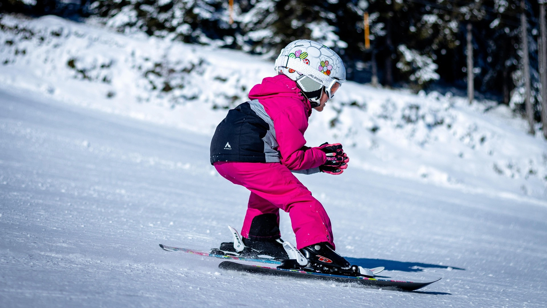 Bild zeigt einen kleinen Jungen beim Skifahren mit Helm.
