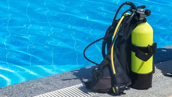 Bild zeigt eine Taucherflasche vor einem Schwimmbecken.
