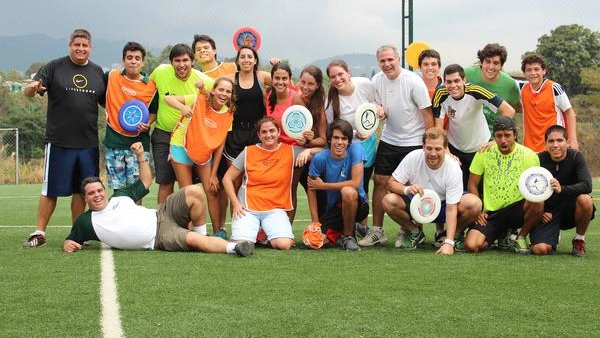 Bild zeigt eine Gruppe, die sich mit Frisbees nebeneinander aufgestellt haben.