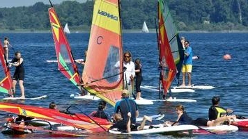 Bild zeigt eine Gruppe beim Windsurfen